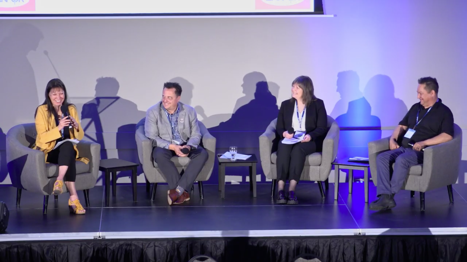 4 men and women sitting on a stage